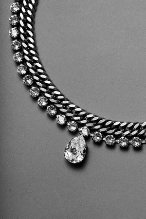 detail of a necklace with pear pendant by ANEIDA Jewelry made in silver plated brass and Swarovski clear crystals